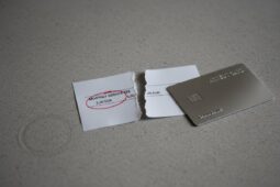 Zerrissener Beleg mit "MONTHLY SERVICE FEE 2,00 EUR" und eine silberne Karte